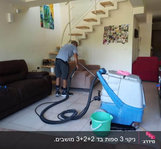 בעל מקצוע מנקה ספת בד בבית הלקוח באמצעות מכונה מקצועית